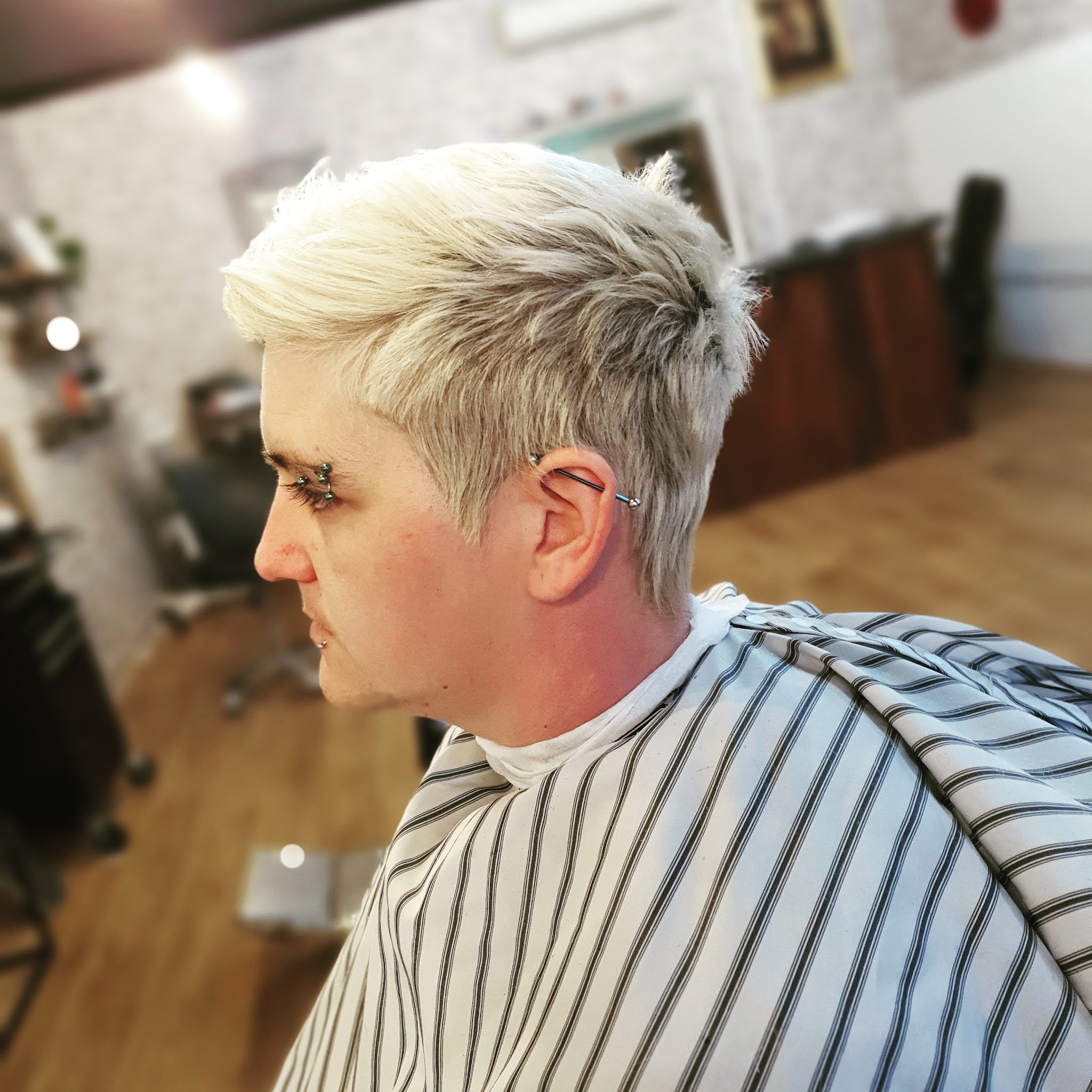 Side profile of a short textured platinum blonde haircut finished at Brother Fox